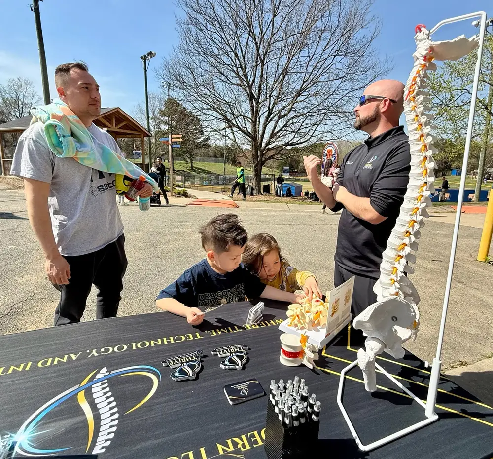 Dr. Hunt teaching families with a spine model at a community event