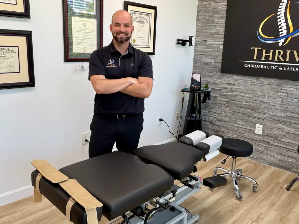 Dr. Hunt standing beside an adjustment table in the clinic